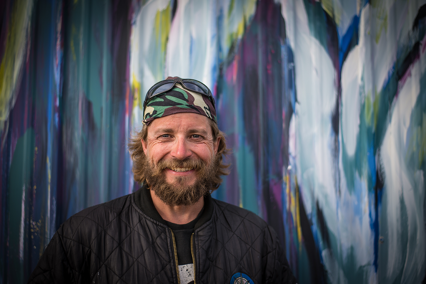 Portrait of a wildlife photographer standing in front of a colourful ice wall at Polar Bear Alley.