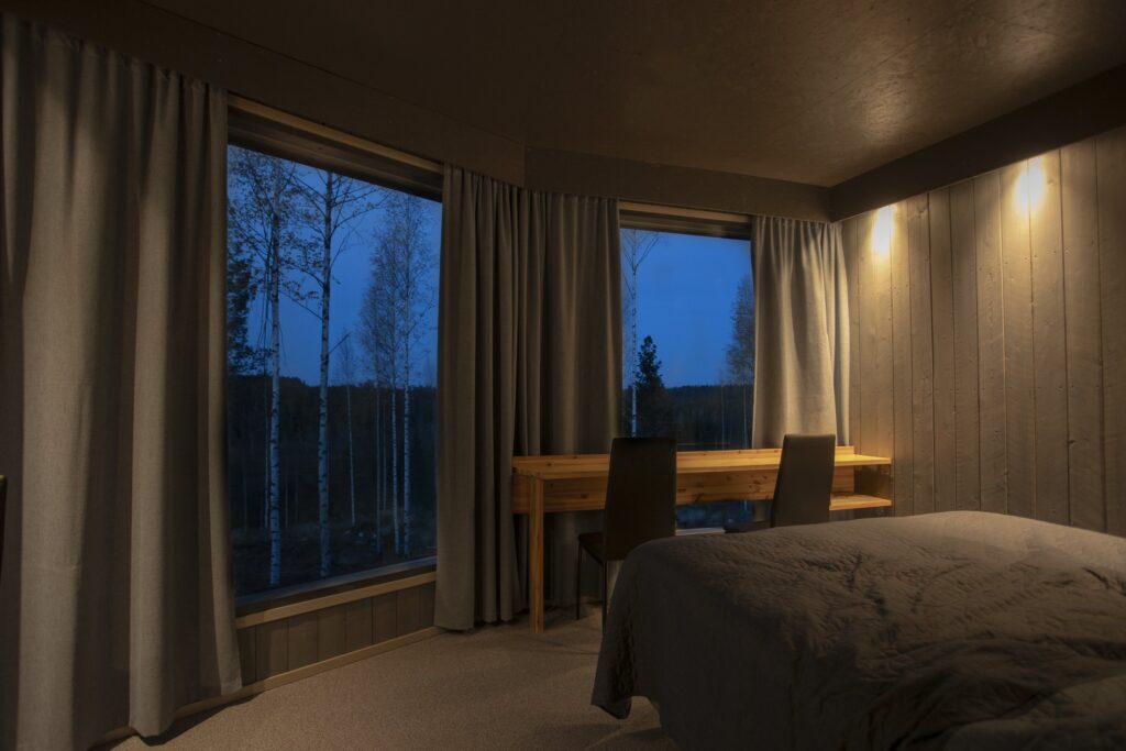 Interior of a luxury bear watching cabin in Finland at dusk with viewing windows .